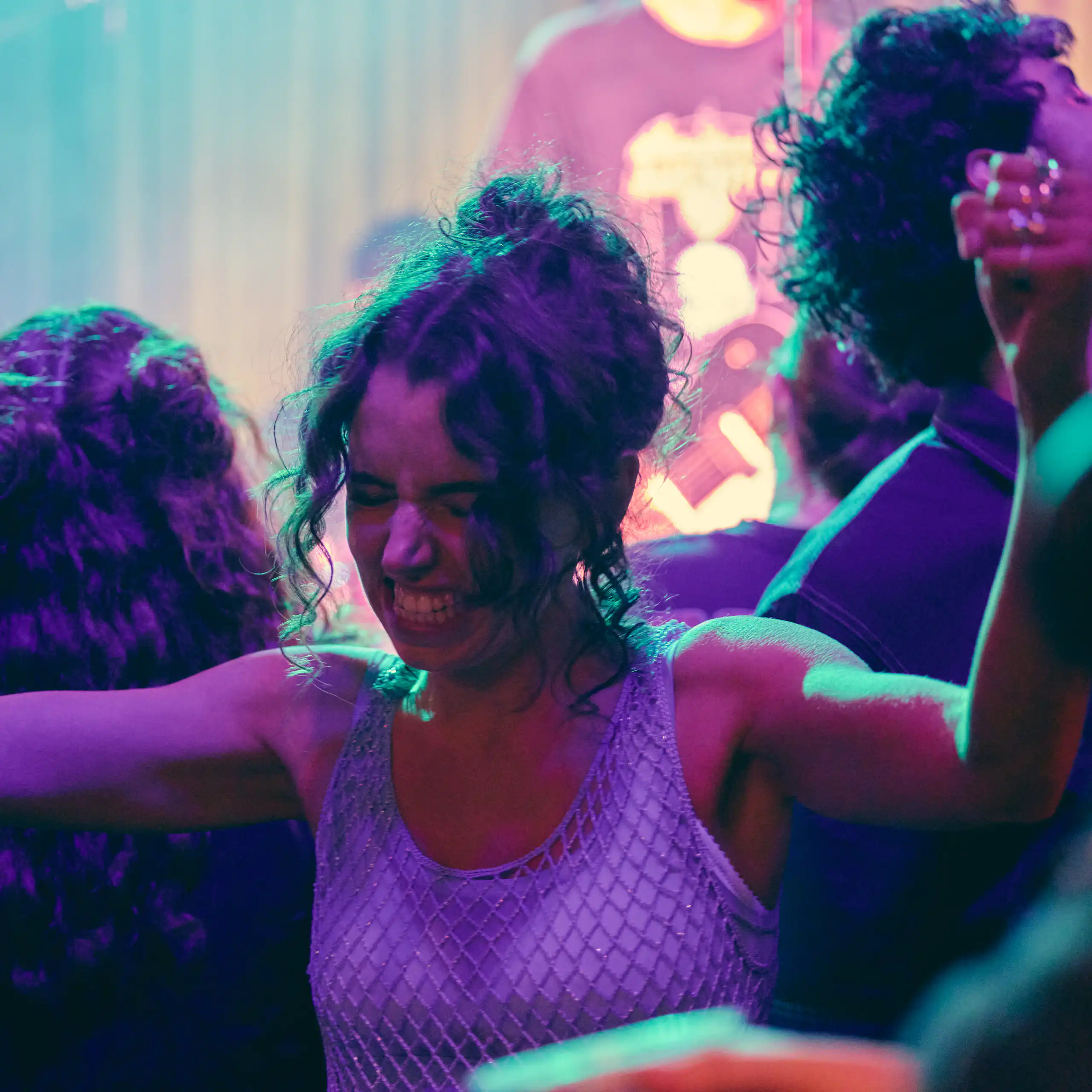 Production image: a young woman in a club.