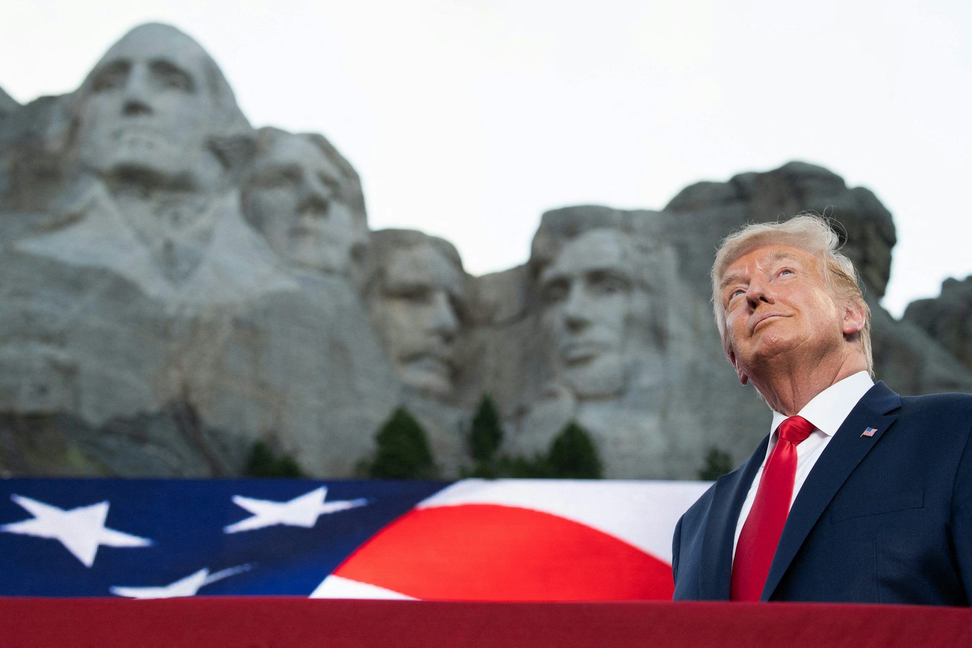 Donald Trump devant le mont Rushmore, vue en contre-plongée.