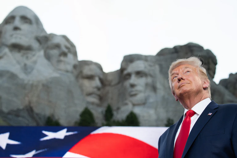Donald Trump devant le mont Rushmore, vue en contre-plongée.