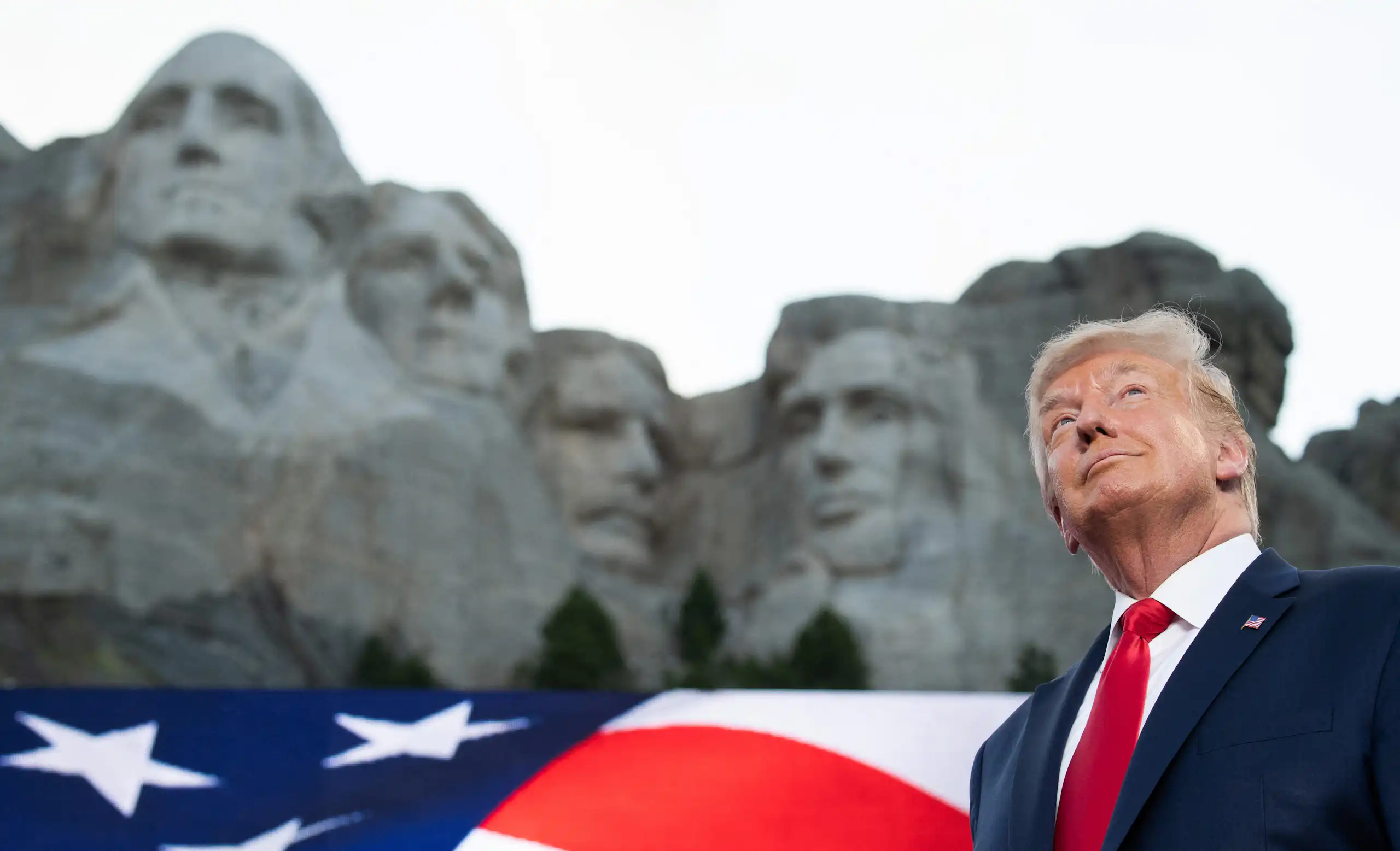 Donald Trump devant le mont Rushmore, vue en contre-plongée.