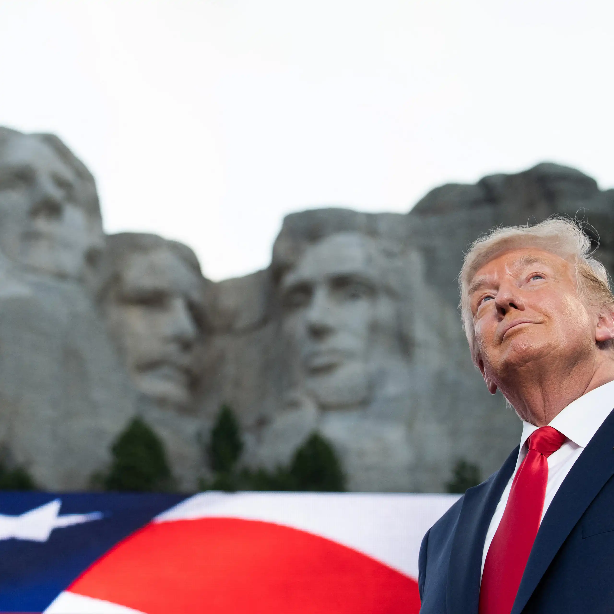 Donald Trump devant le mont Rushmore, vue en contre-plongée.