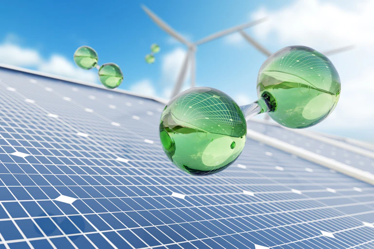 La molécula de hidrógeno verde que flota sobre paneles solares y dos aerogeneradores al fondo