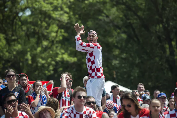 People in red-and-white checked shirts in a public space.