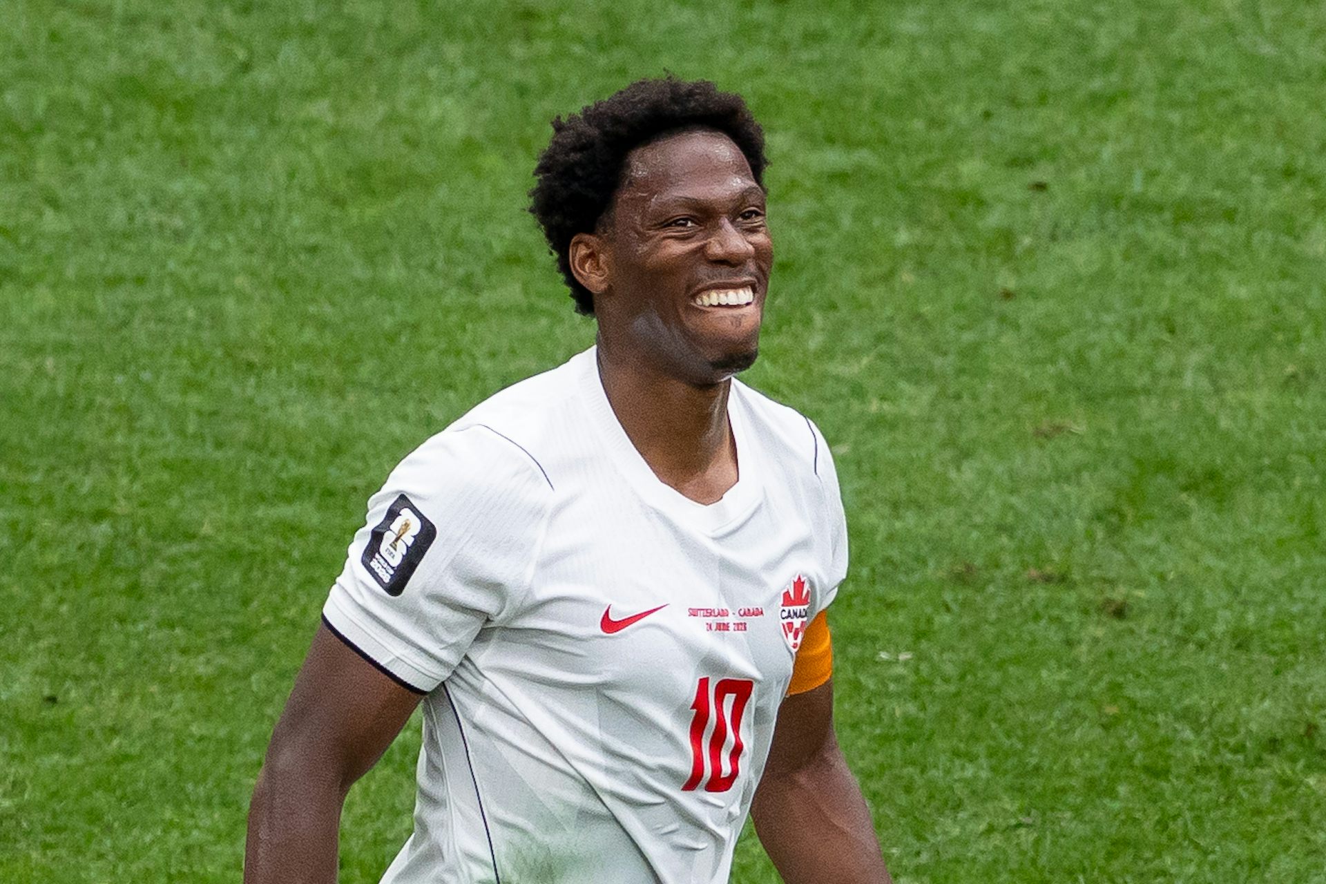 Un hombre negro con una camiseta de fútbol blanca.