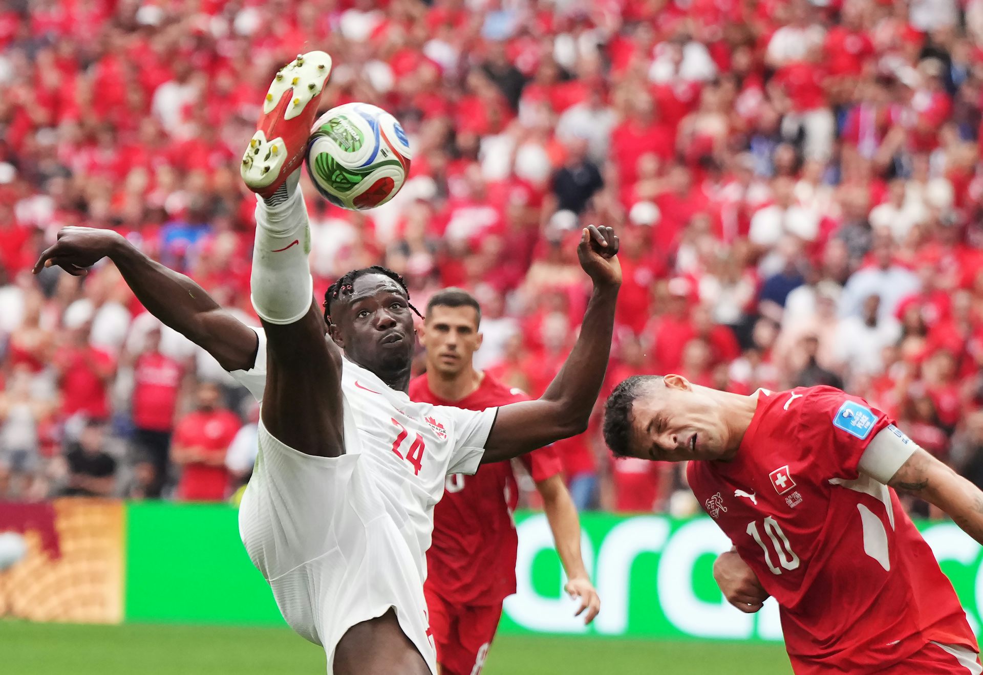 Un footballeur frappe un ballon en hauteur.