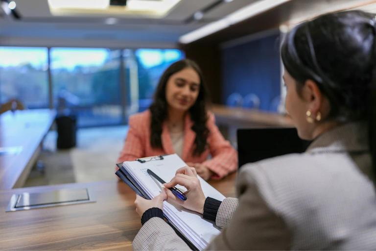 A woman interviews a young woman for a job