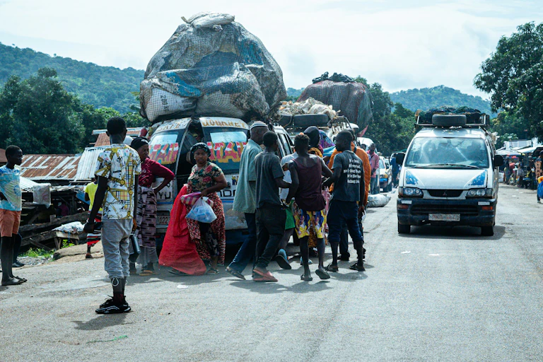 Des camionnettes chargées de matières récupérées arrivent près d'un marché achalandé dans un pays africain.
