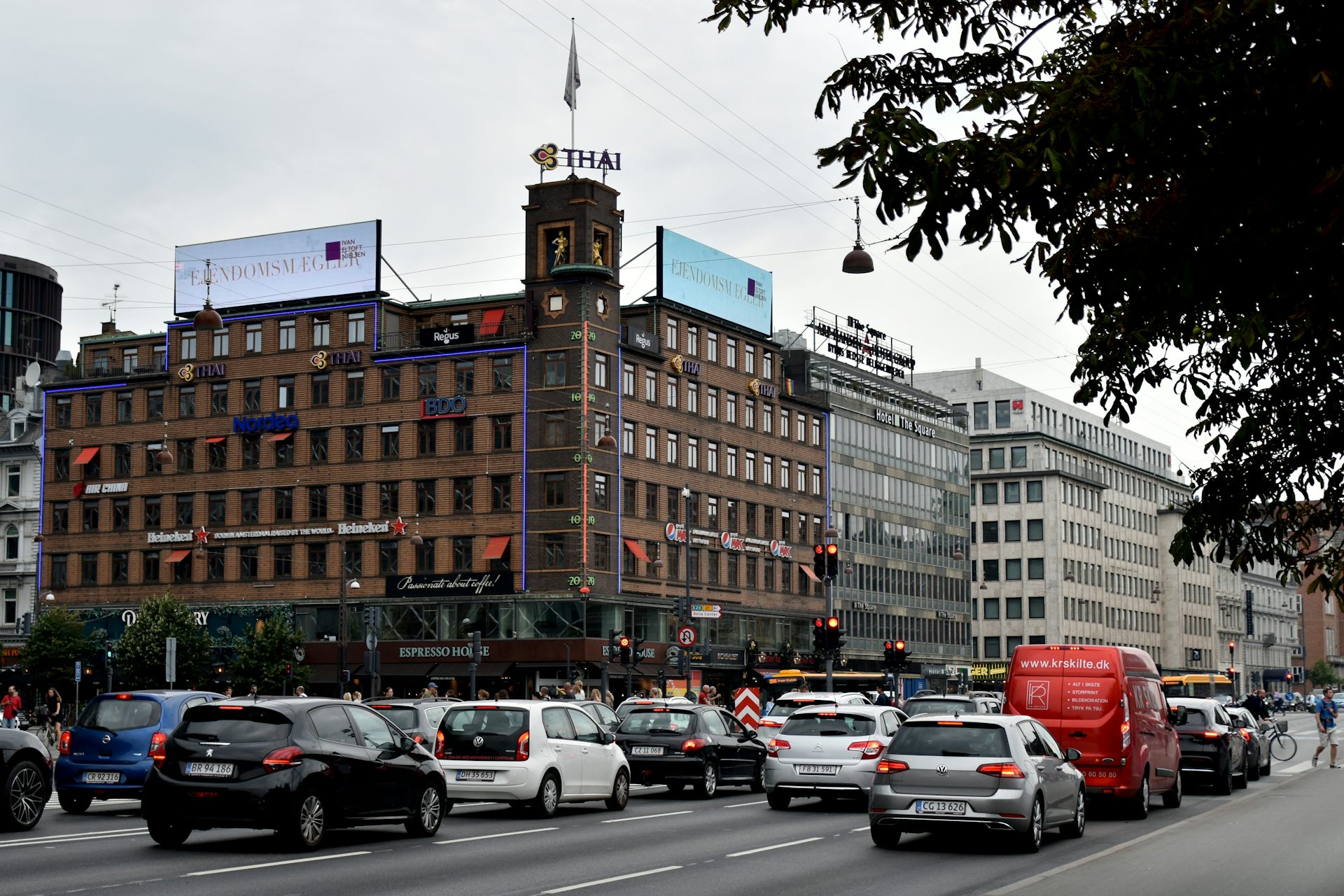 A large thermometer mounted on the side of a building in busy street in Copenhangen, Denmark.