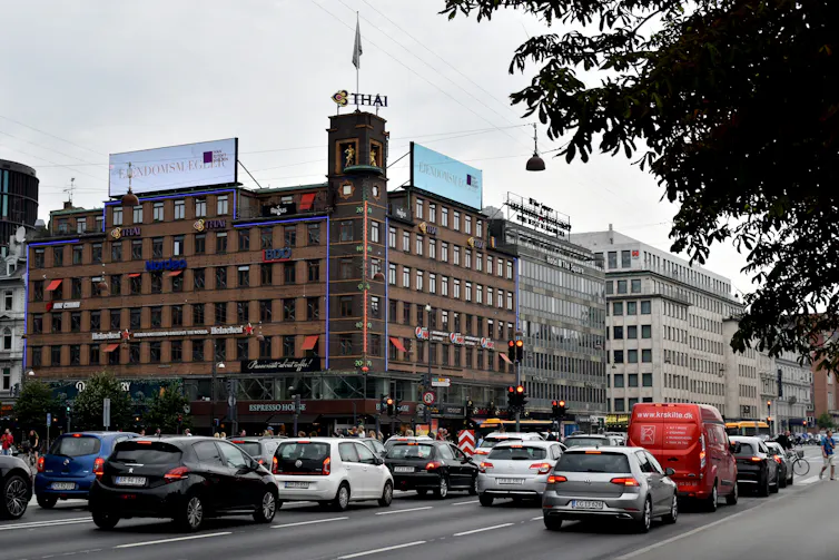 A large thermometer mounted on the side of a building in busy street in Copenhangen, Denmark.