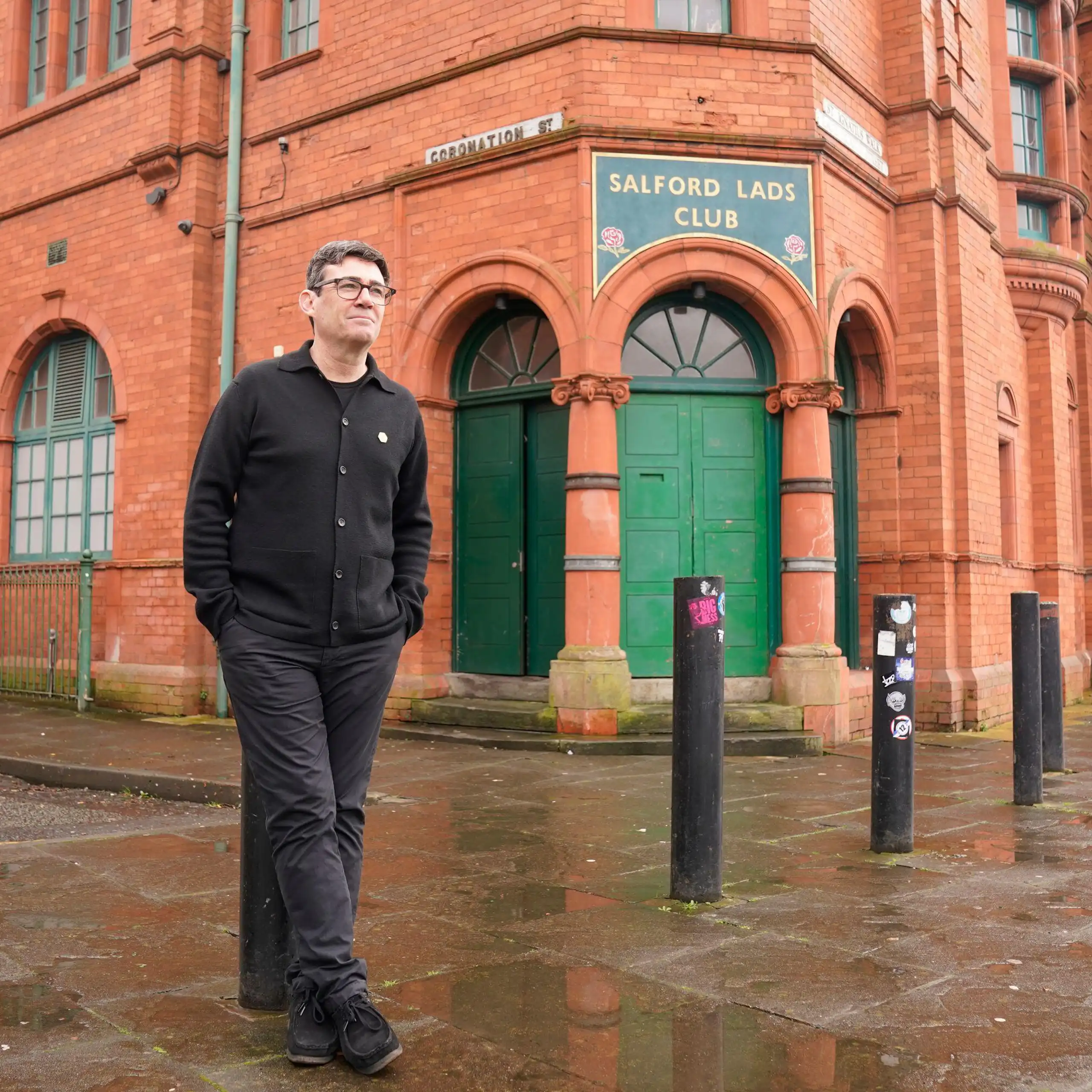 Man stands outside redbrick social club.