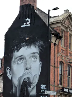 Paining of a singer on side of a building.