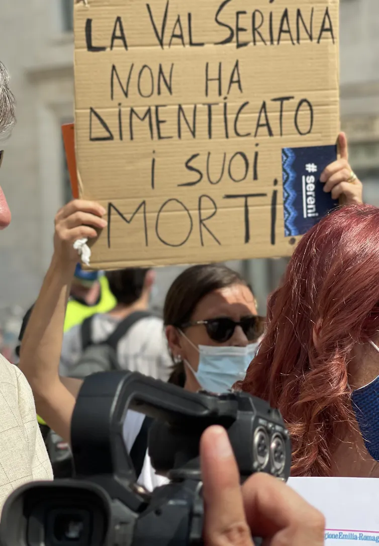 Lors de la manifestation de l’association Sereni, devant la mairie de Bergame, pour réclamer une commission d’enquête gouvernementale, une manifestante porte un panneau sur lequel est écrit : « La vallée Seriana n’a pas oublié ses morts », Italie