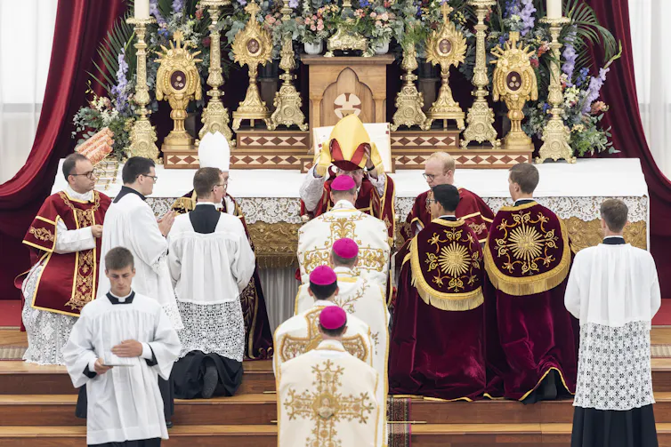 Four new bishops are consecrated in a Catholic church.