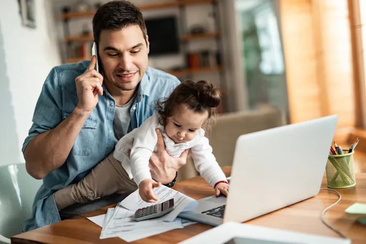 Dad on phone while holding a baby