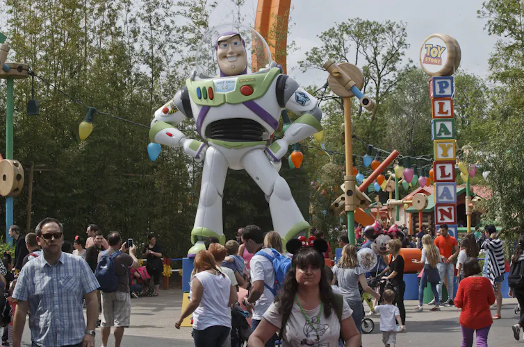 En Toy Story 5, es tecnología versus juguetes, algo con lo que las familias luchan 1 Los turistas deambulan por la concurrida zona debajo de un astronauta de juguete gigante que dice