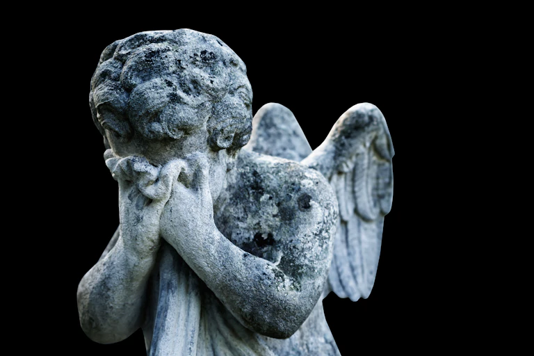 Anjo triste como símbolo de dor e morte. Estátua antiga isolada sobre um fundo preto