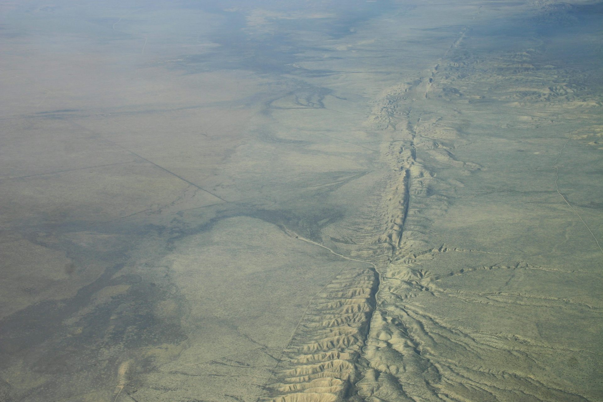 Vue aérienne d’une large rupture dans le sol d’un désert