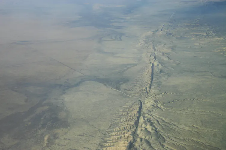 Vue aérienne d’une large rupture dans le sol d’un désert