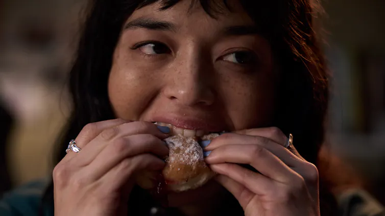 Production image: close-up of Hana eating a donut.