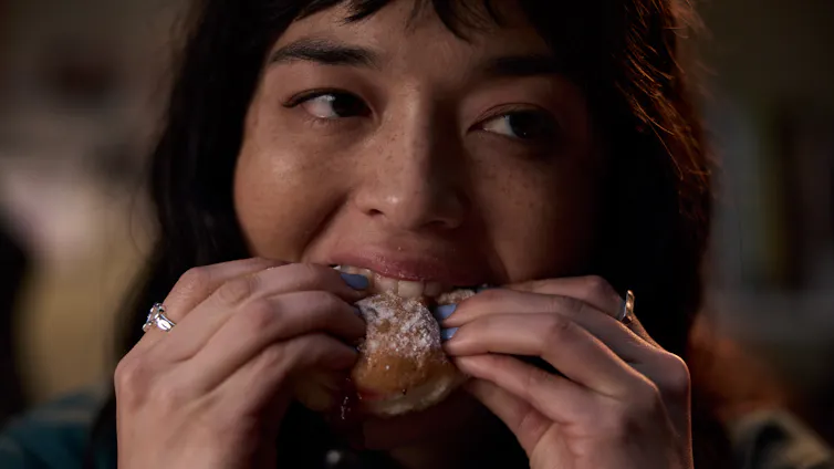 Production image: close-up of Hana eating a donut.