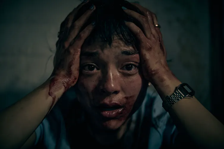 Production image: Hana's face is covered in blood.