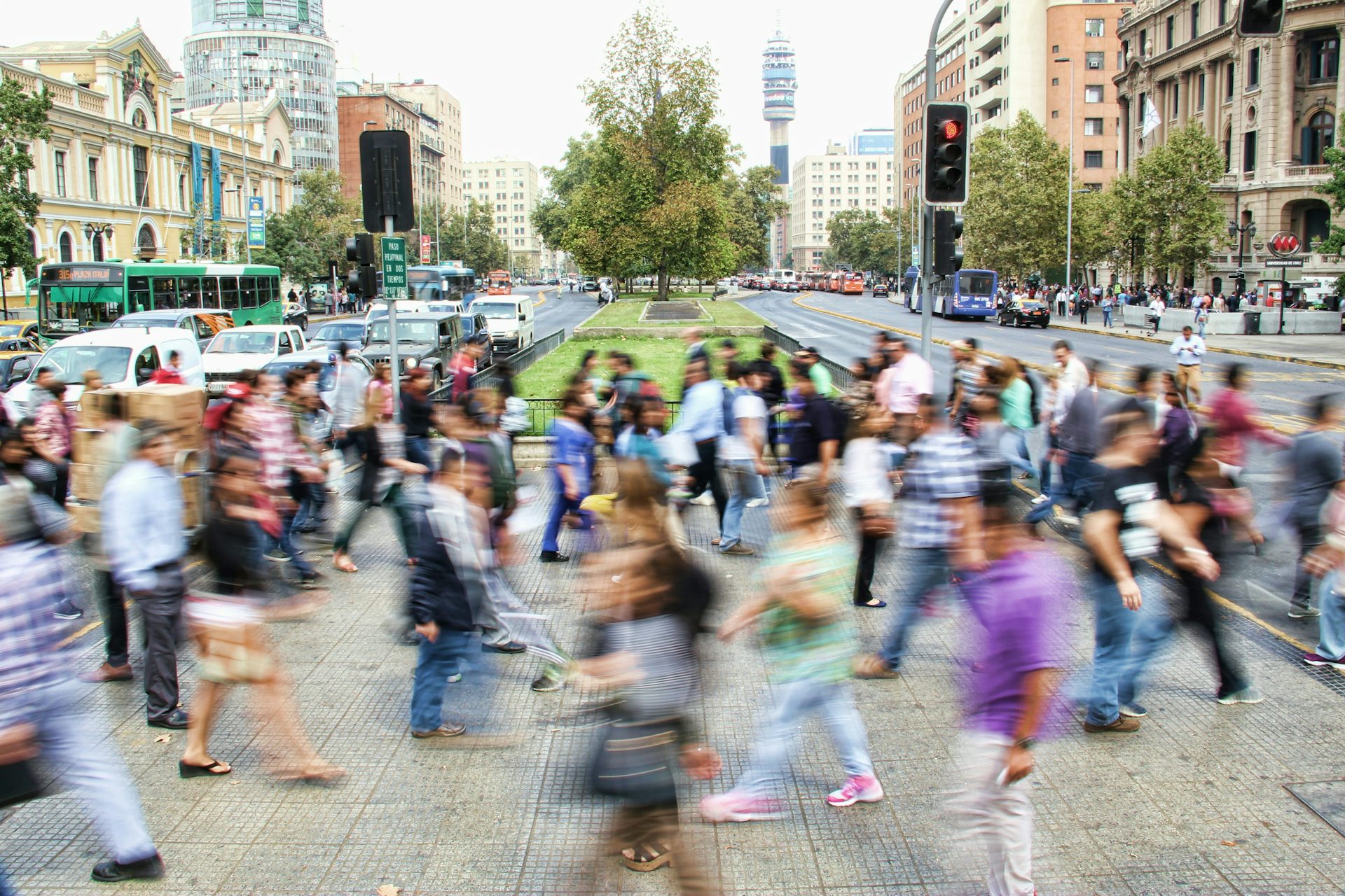 Imagen borrosa de gente caminando con ropa colorida en un moderno centro de la ciudad.