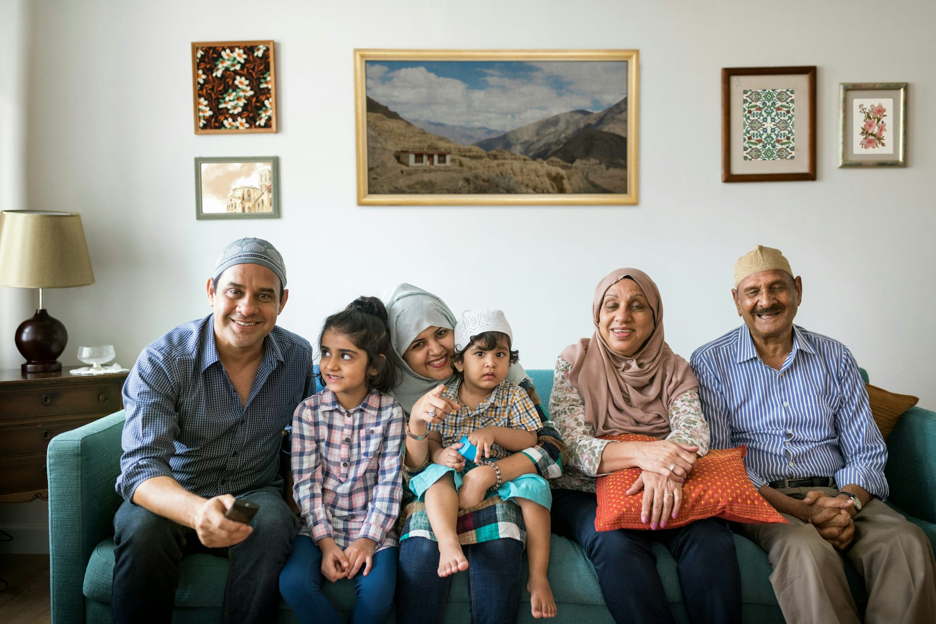 Una familia afgana multigeneracional sentada en un sofá.