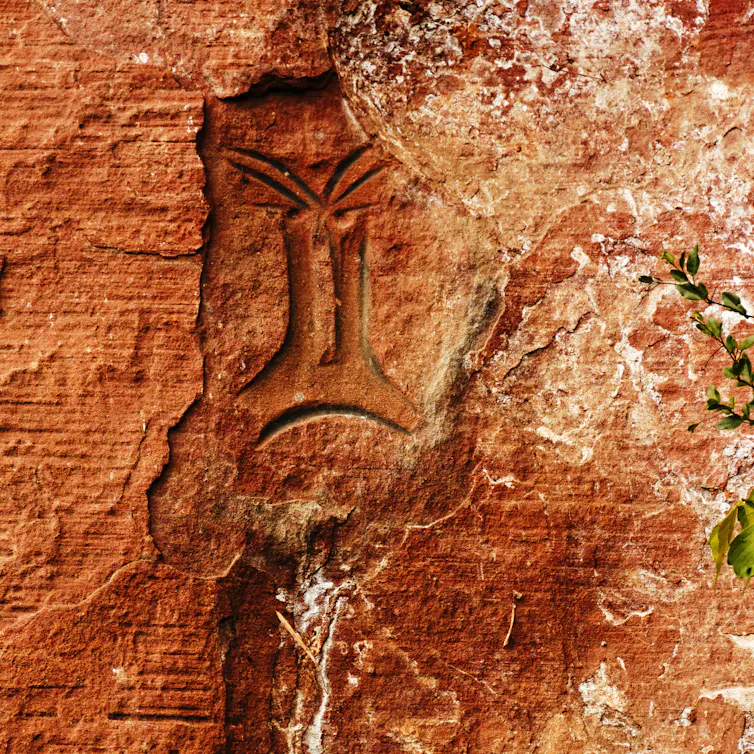 orange rock with old rock art painted on