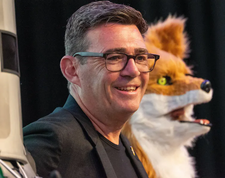 Andy Burnham and a man dressed as a fox.