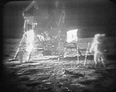 Deux astronautes marchent à la surface de la Lune