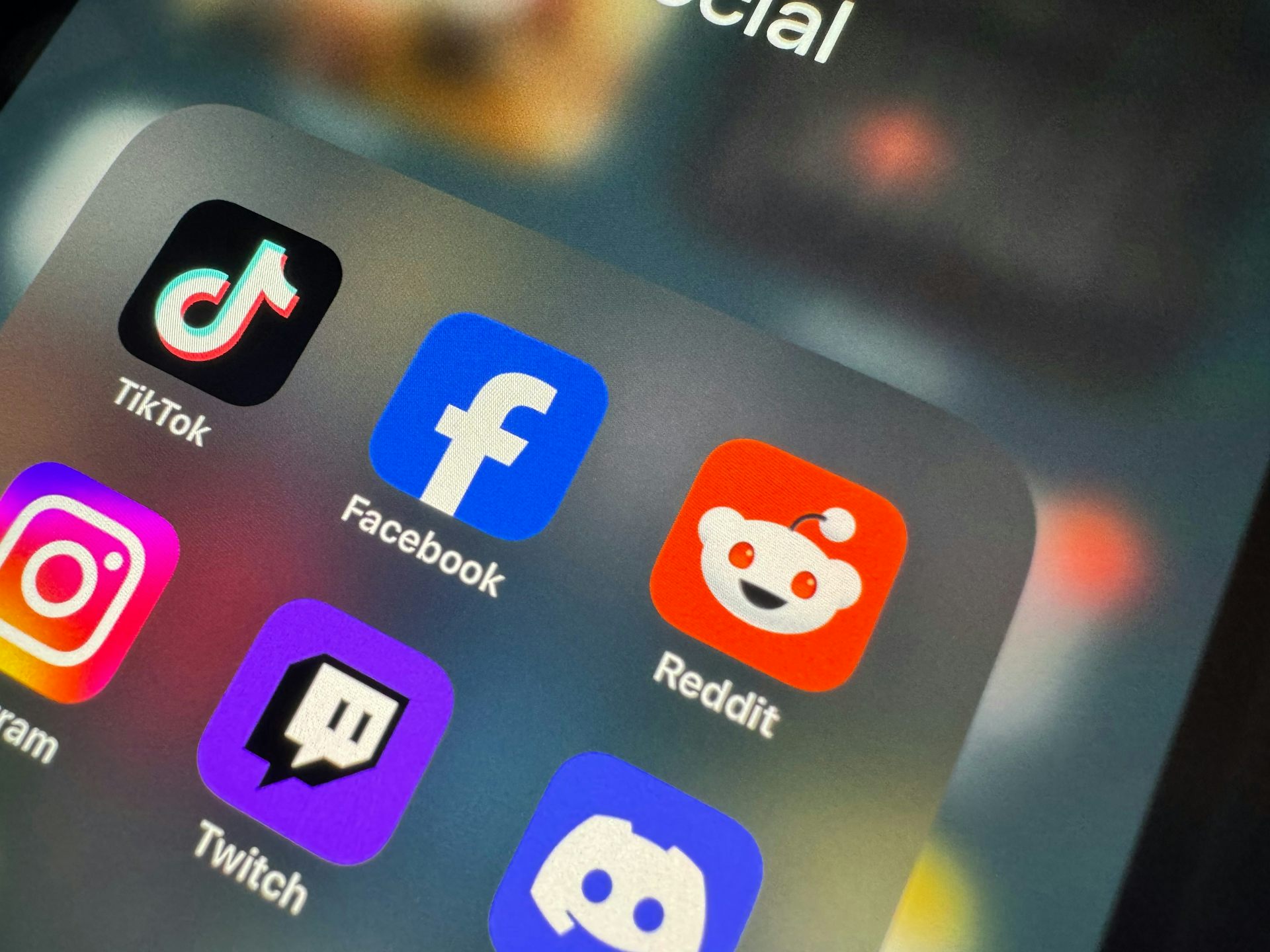 Apps, including TikTok, Reddit, and Twitch, are displayed on a phone screen