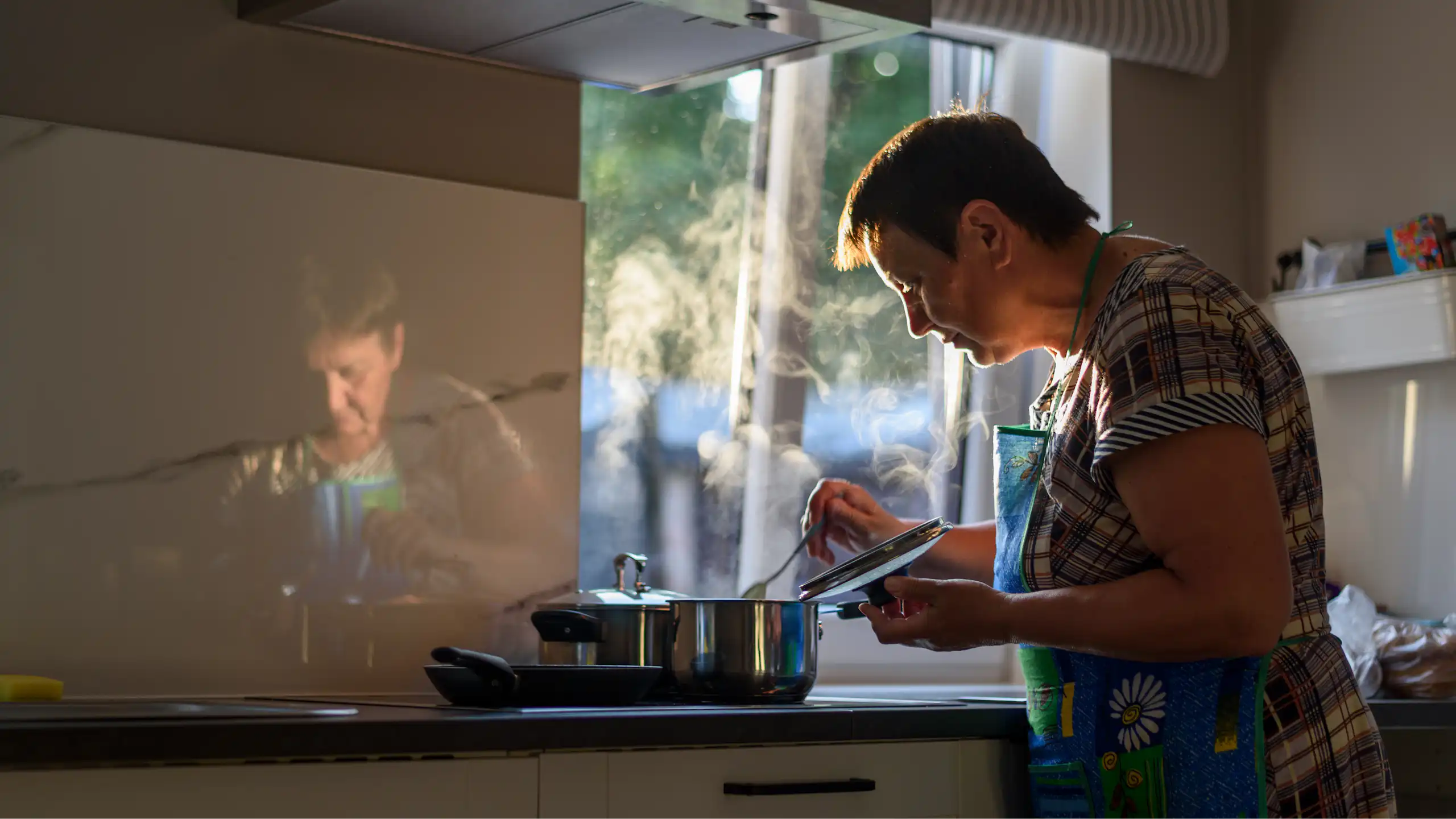 An older woman cooks in her kitchen