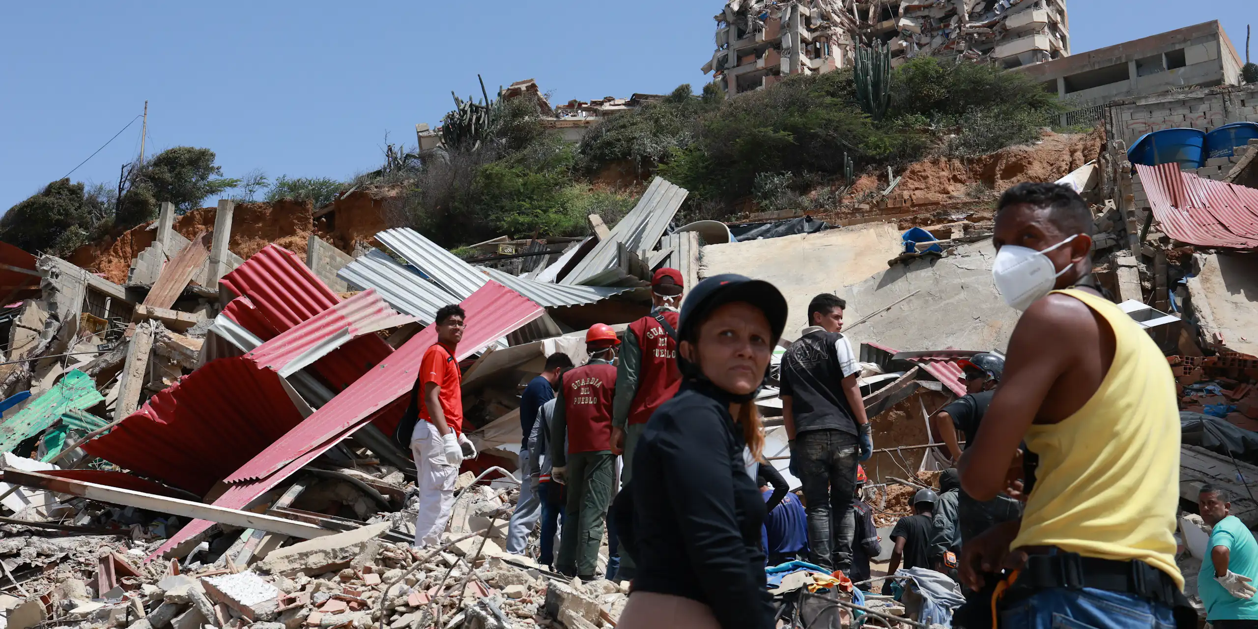 People digging through the remnants of a collapsed building