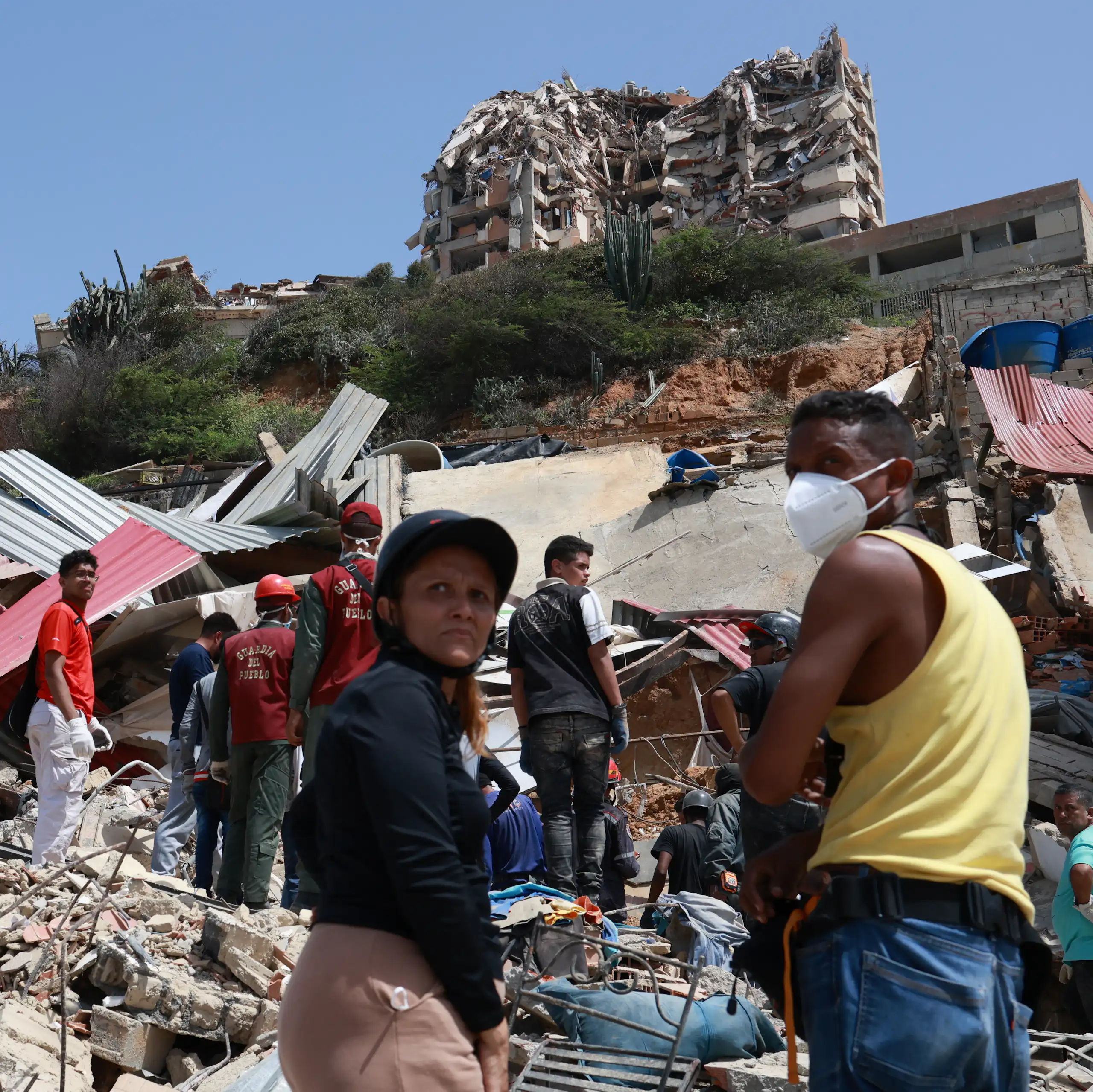 People digging through the remnants of a collapsed building