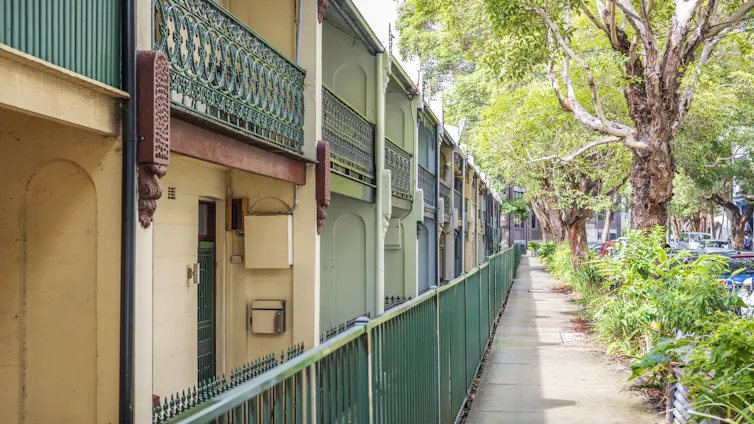 line of older terrace houses, footpath and trees in inner Sydney.