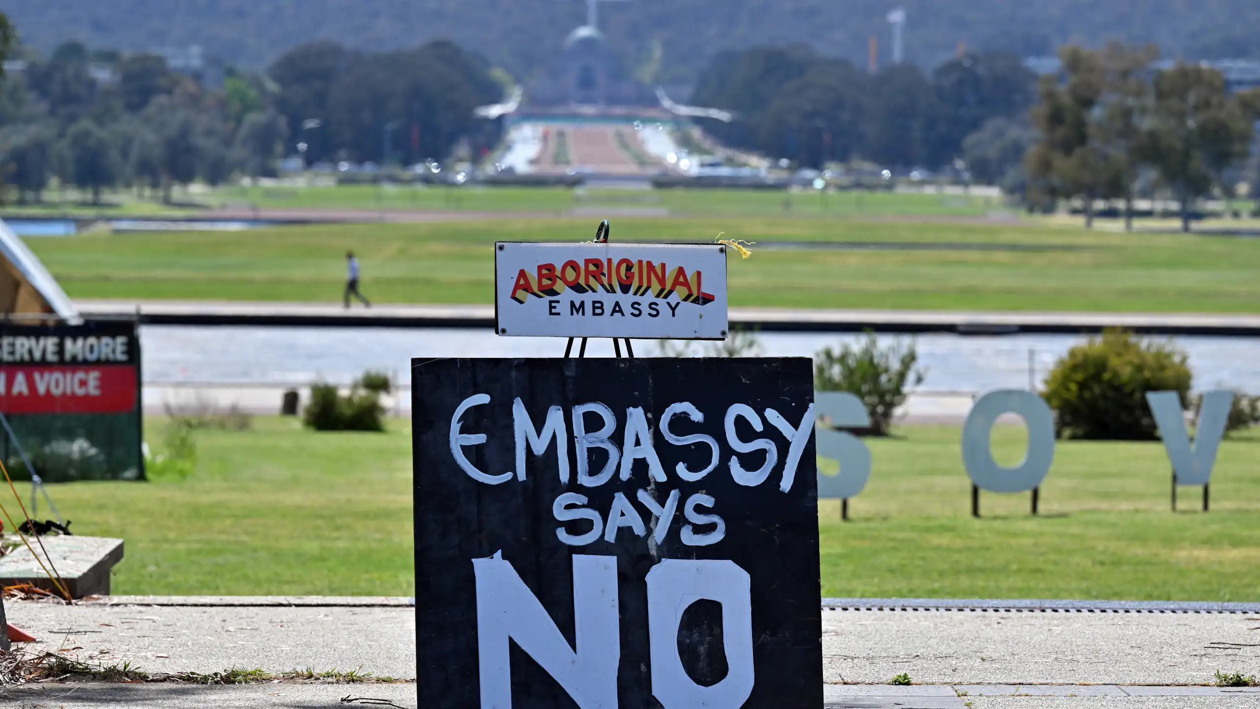 Aboriginal tent embassy, Canberra, with Parliament House in the background.