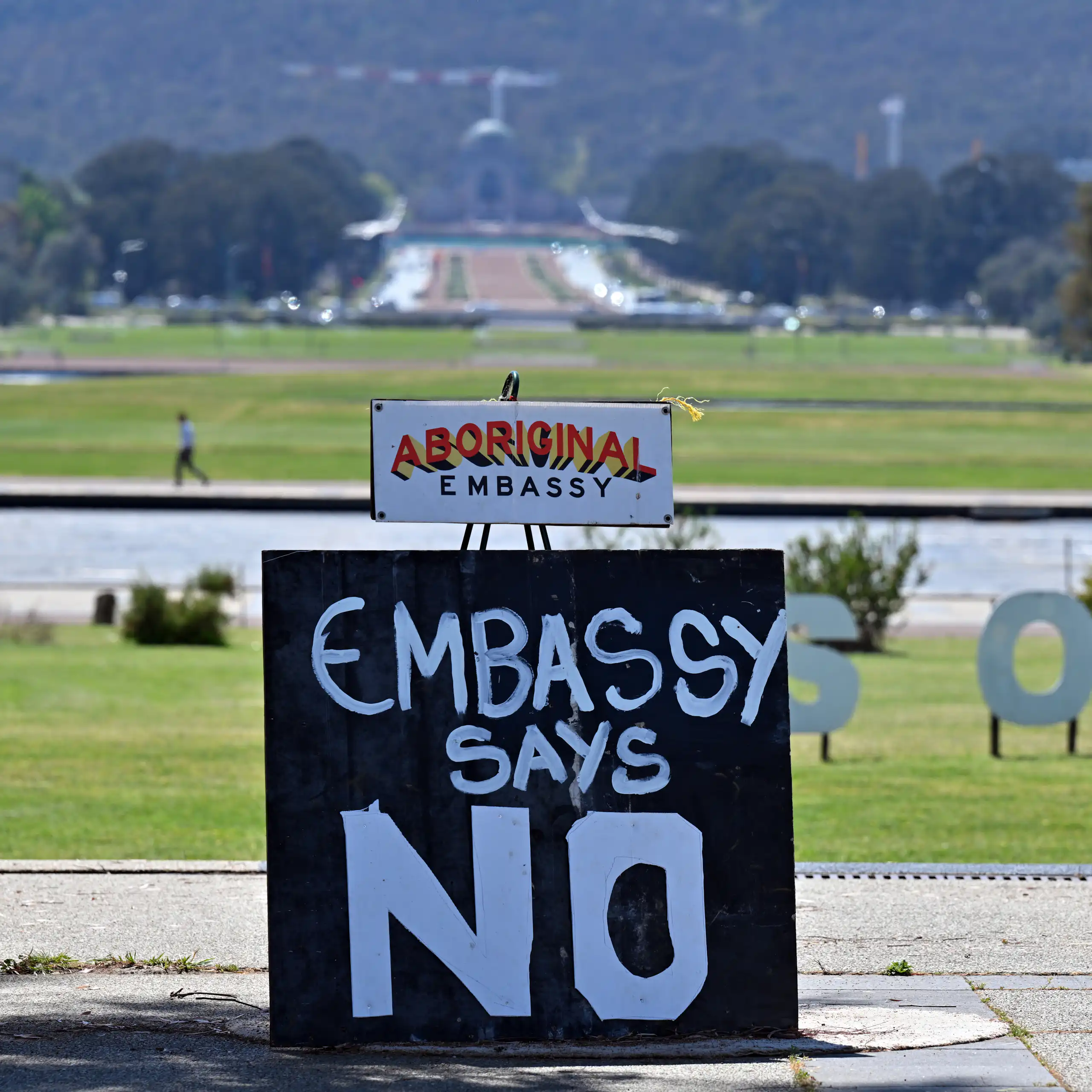 Aboriginal tent embassy, Canberra, with Parliament House in the background.