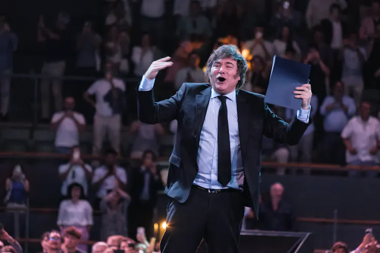 Javier Milei addressing the audience from a stage at a conference in Madrid, Spain.