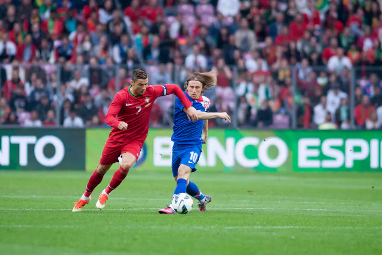 El delantero de la selección portuguesa Cristiano Ronaldo y el jugador croata Luka Modric disputan un balón.