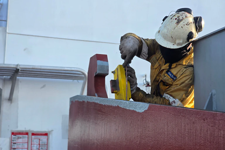 Worker in hard hat, gloves and overalls