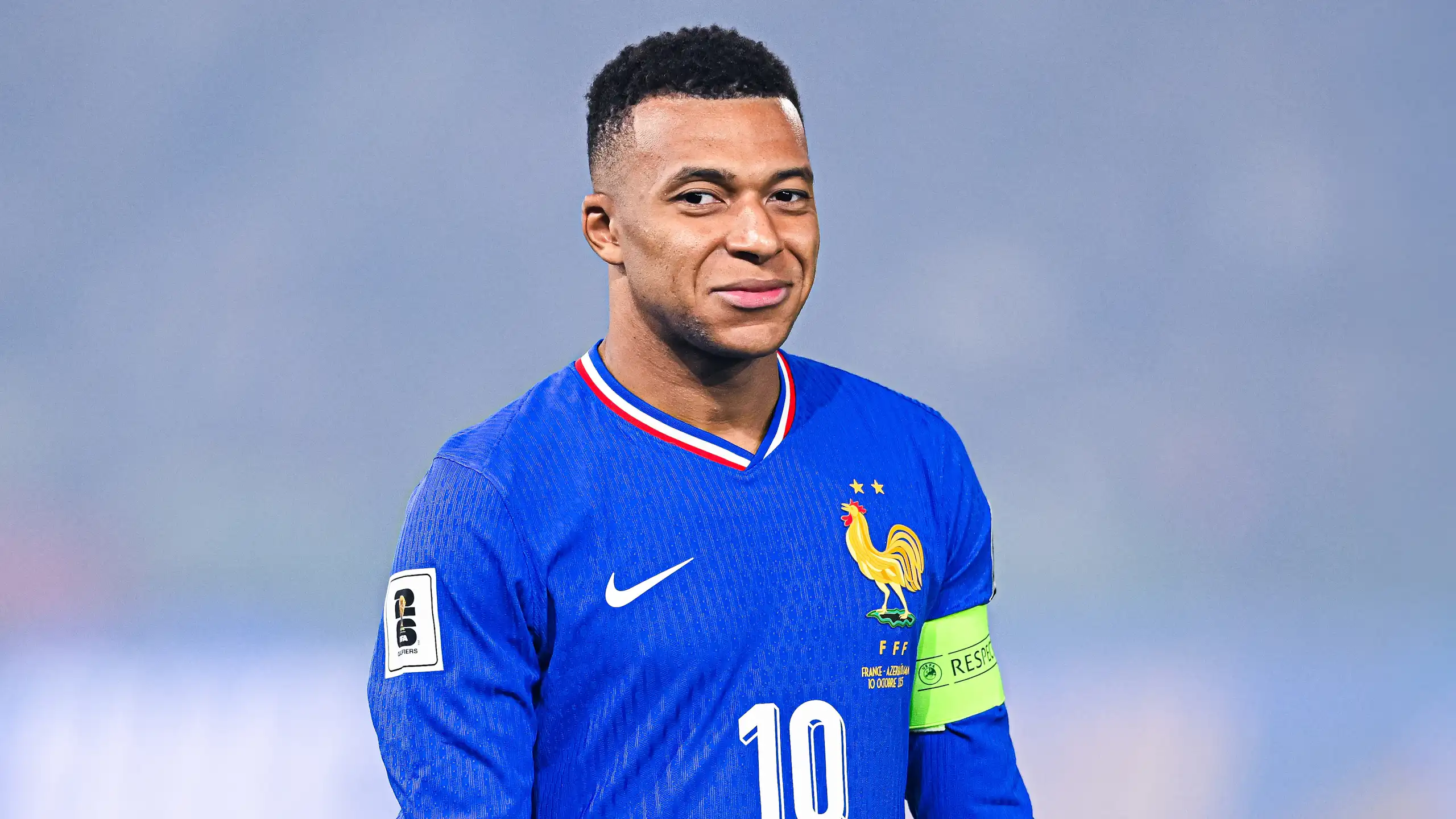 Portrait de Mbappé souriant.