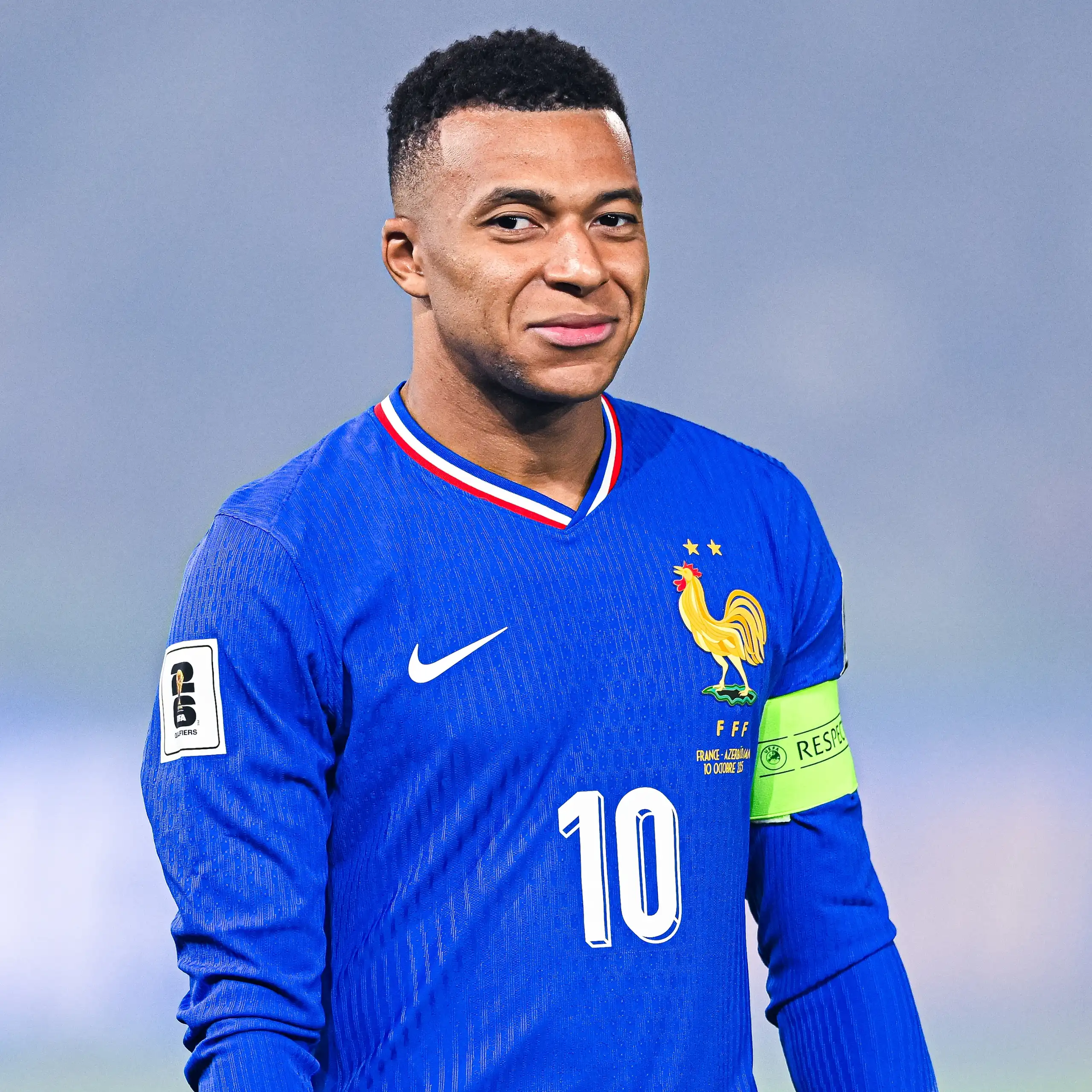 Portrait de Mbappé souriant.