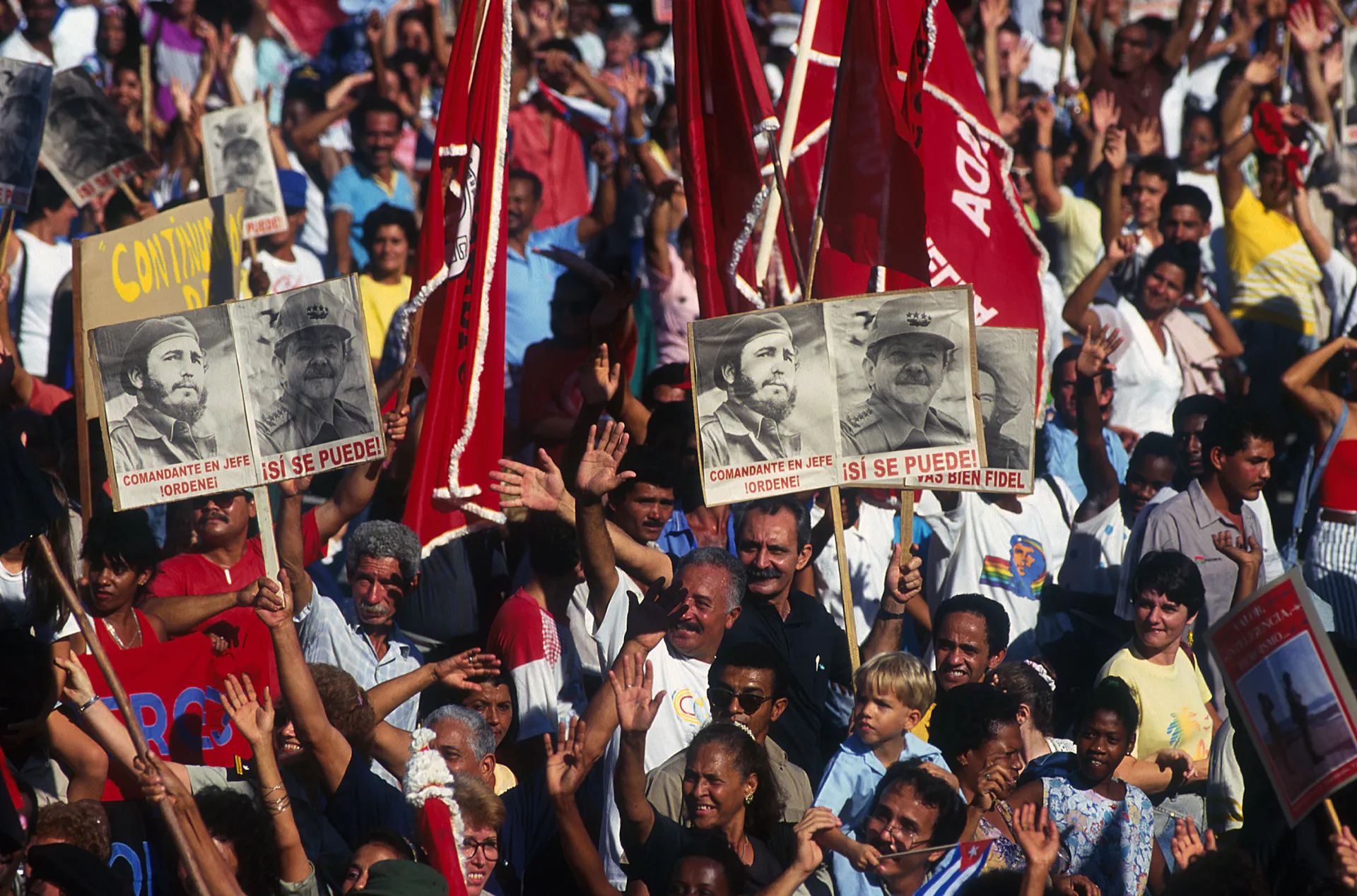 A crowd holds aloft photos of two men.
