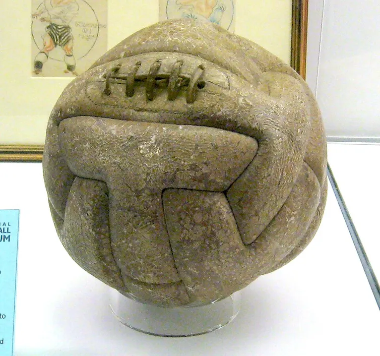 Un balón de fútbol antiguo en un expositor de museo