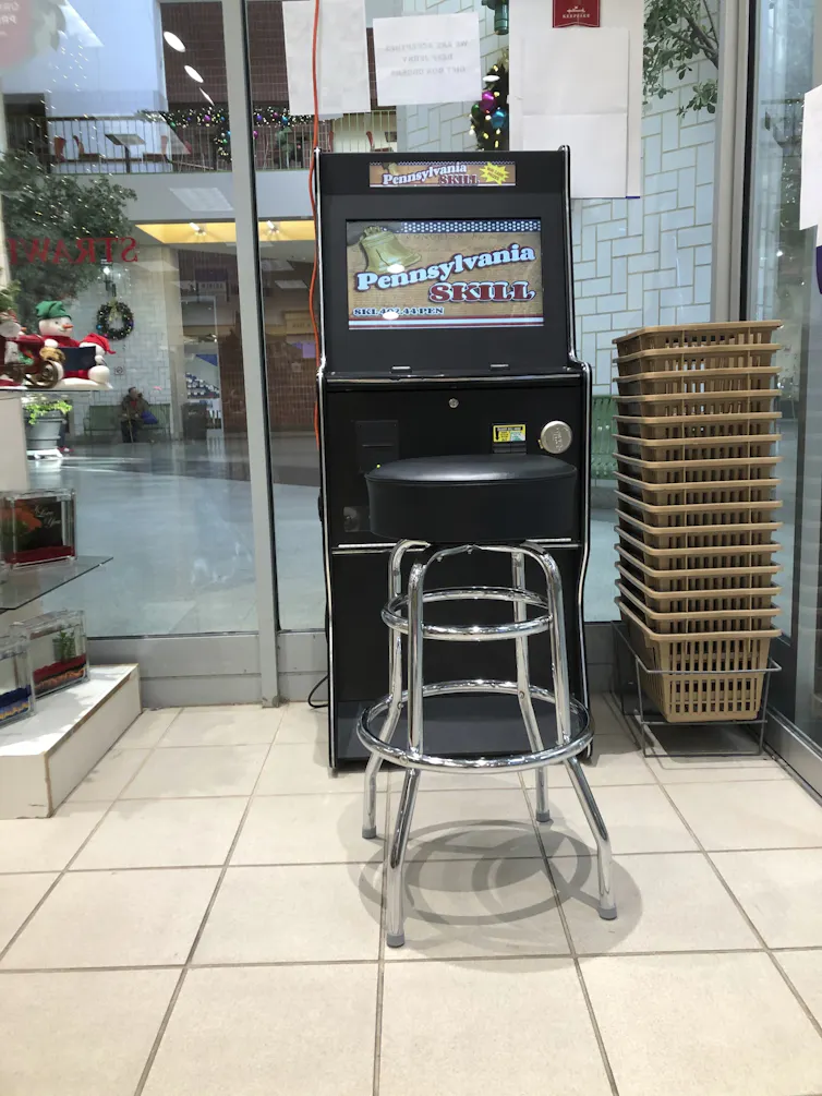 A stool sits in front of a gambling machine that reads