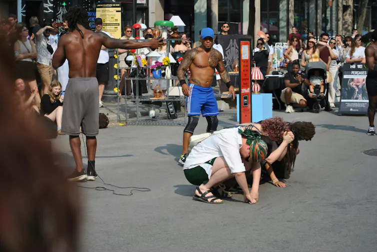 Des danseurs font une performent dans la rue, lors d’une chaude journée sous le soleil