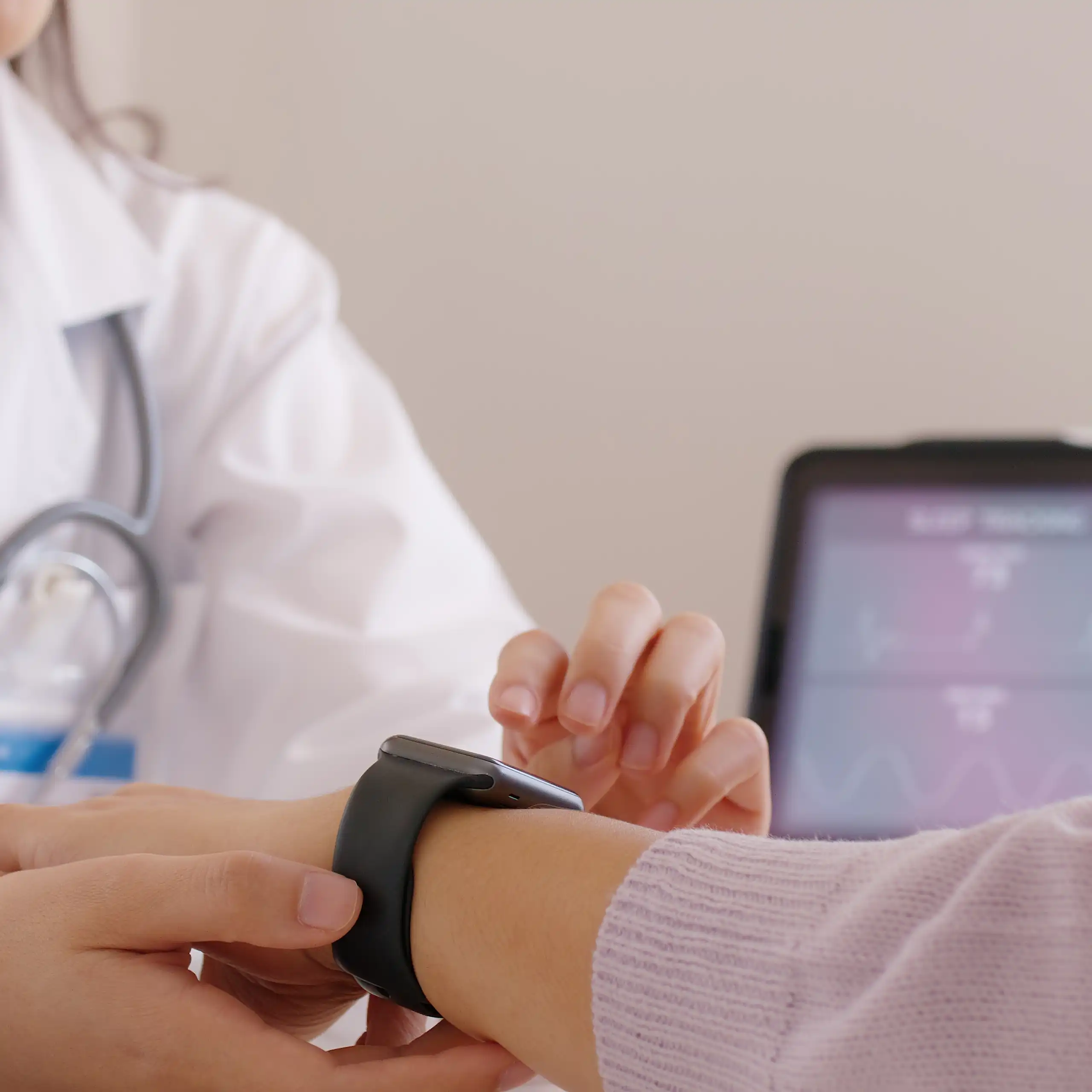 Une soignante manipule une montre connectée au bras d’un patient.