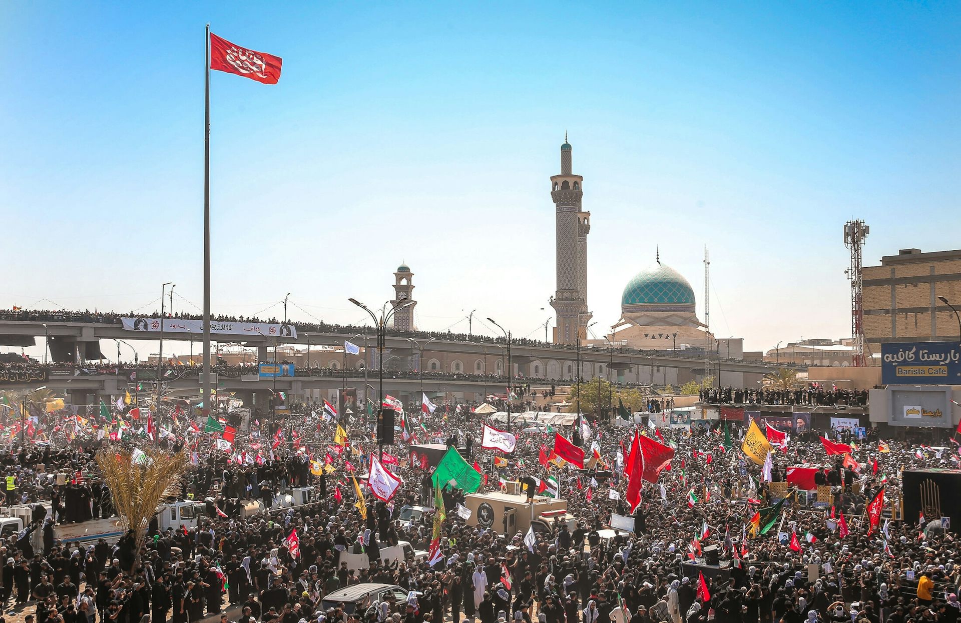 A crowd wave flags at the funeral ceremony of Ali Khamenei in the Iraqi city of Najaf.