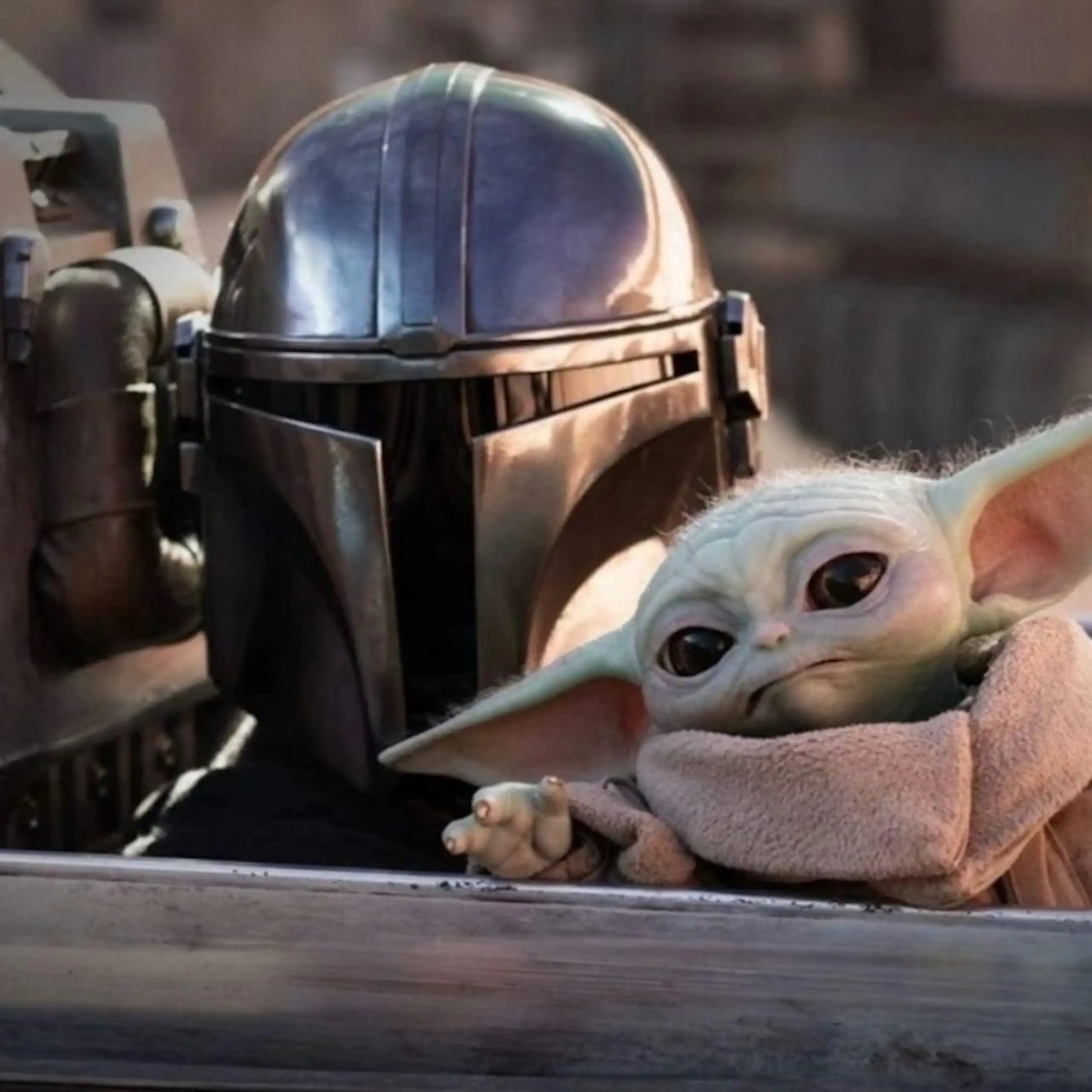 Capture d'écran du film, gros plan sur le personnage principal Din Djarin et son compagnon, Grogu.