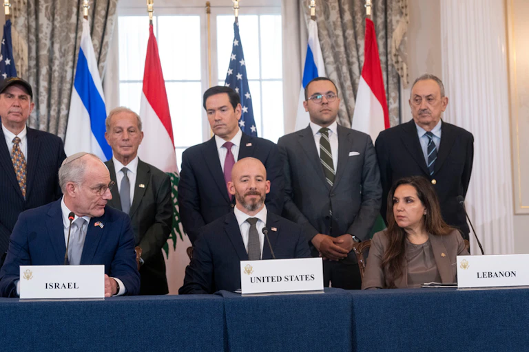 Several people in suits gather at a press conference.